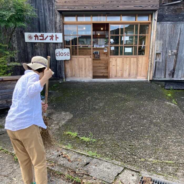 写真：小清水が店頭を竹箒で掃いています。