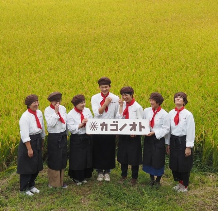 写真：スタッフが田んぼの前で集合しています