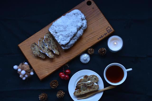 写真：シュトーレンがカッティングボードに並んでいます。紅茶やクリスマス飾りと設られています。