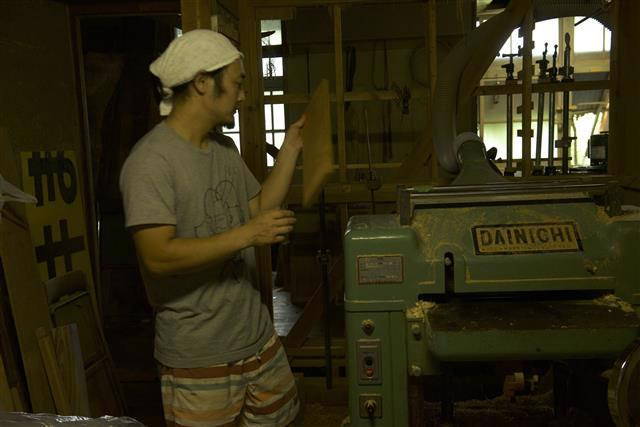 写真：カッティングボードを製材する村井さんです。