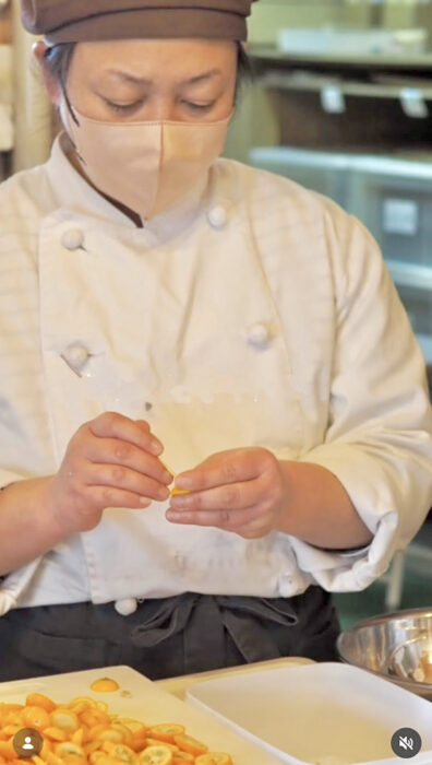 写真：スタッフたけださんが、竹串で金柑の種を一つひとつ取り除いています